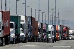 In this July 22, 2019 photo, trucks hauling shipping containers wait to unload at the Port of Oakland in Oakland, Calif.
