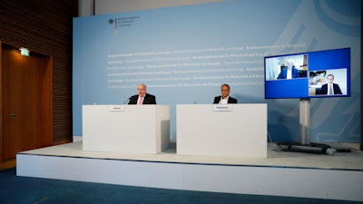 German Economy Minister Peter Altmaier, left, state secretary at the economic ministry Ulrich Nussbaum, right, attend a news conference with investor Dietmar Hopp, screen left, and CureVac CEO Franz-Werner Haas, screen right, in Berlin, June 15, 2020.