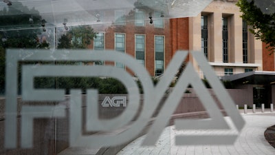 The Food and Drug Administration building visible behind FDA logos at a bus stop in Silver Spring, Md., Aug. 2, 2018.