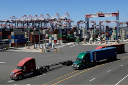 Trucks travel along a loading dock at the Port of Long Beach in Long Beach, Calif.