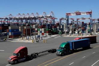 Trucks travel along a loading dock at the Port of Long Beach in Long Beach, Calif., Aug. 22, 2018.