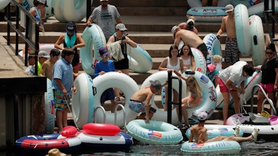 Tubers prepare to float the Comal River, despite the recent spike in COVID-19 cases, June 25, 2020, in New Braunfels, Texas.