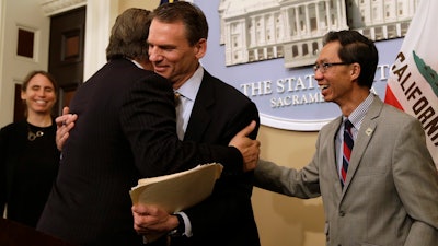 California state Sen. Bob Hertzberg, D-Van Nuys, left, and Assemblyman Ed Chau, D-Arcadia, right, celebrate with Alastair Mactaggart, center, after the Legislature approved their data privacy bill in Sacramento, June 28, 2018.