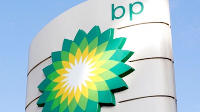 This Tuesday, Aug. 1, 2017 file photo shows the BP logo at a petrol station in London. Energy company BP is writing off as much as $17.5 billion from its oil and gas assets and will review its plans to develop oil wells as the COVID-19 pandemic accelerates its goal of decreasing its reliance on fossil fuels.