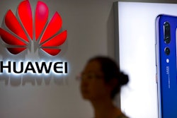 A shopper walks past a Huawei store in Beijing, July 4, 2018.