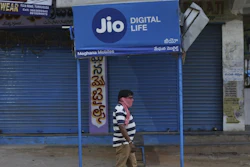 A man walks past a Reliance Jio sign in front of a closed shop in Hyderabad, India, April 22, 2020.