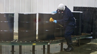 A worker decontaminates steel drums containing yellowcake uranium at UR Energy's Lost Creek facility, Sweetwater Co., Wyo., Dec. 9, 2013.