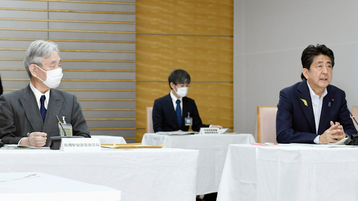 Japanese Prime Minister Shinzo Abe, right, at a government meeting on space development at his office in Tokyo, June 29, 2020.
