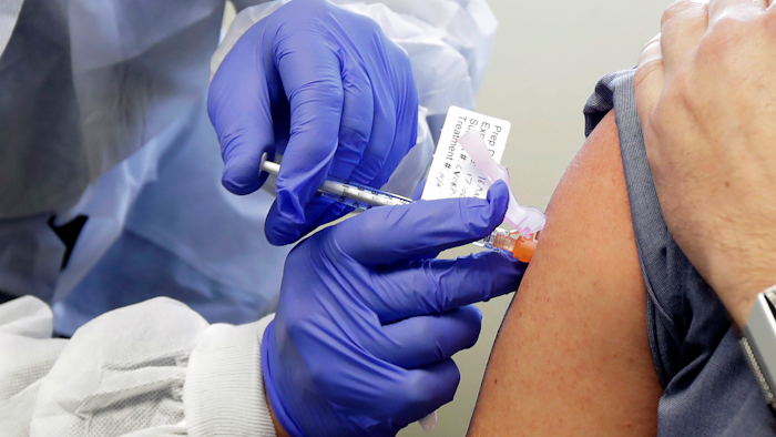 A subject receives a shot in the first-stage safety study clinical trial of a potential vaccine for COVID-19 at the Kaiser Permanente Washington Health Research Institute in Seattle, March 16, 2020.