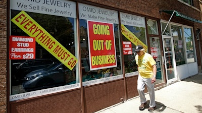 A man walks past a retail store that is going out of business due to the coronavirus pandemic in Winnetka, Ill., June 23, 2020.
