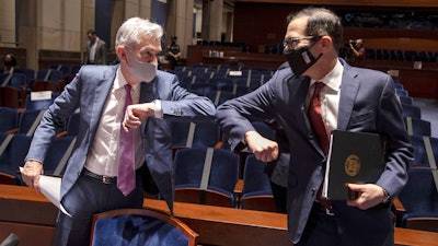 Federal Reserve Board Chairman Jerome Powell, left, and Treasury Secretary Stephen Mnuchin bump elbows at the conclusion of a House Committee on Financial Services hearing, June 30, 2020 on Capitol Hill.