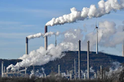 Uniper coal-fired power plant and BP refinery steam beside a wind generator in Gelsenkirchen, Germany.