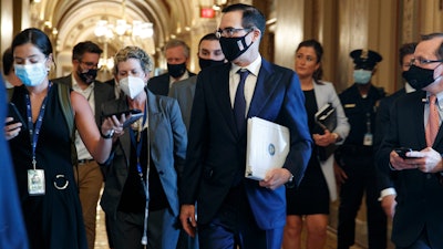 Treasury Secretary Steven Mnuchin , center, walks to a Republican luncheon on Capitol Hill, July 21, 2020.