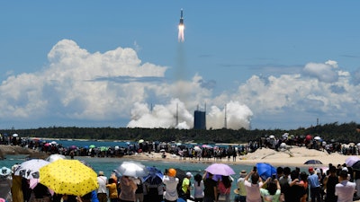 Spectators watch the Long March-5 rocket, carrying the Tianwen-1 Mars probe, lift off from the Wenchang Space Launch Center, July 23, 2020.