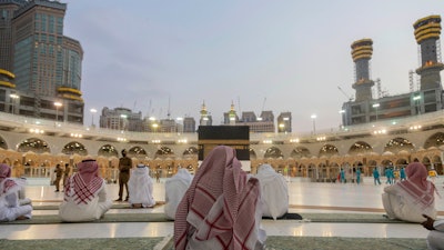 Pilgrims pray around the Kaaba, the square structure in the Great Mosque, Mecca, Saudi Arabia, July 26, 2020.