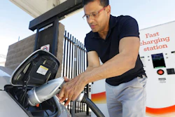 Man charges electric car at fast charging station.