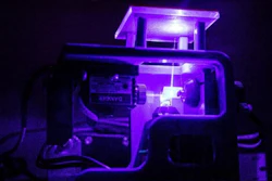 Laser beam transmitting upwards through glass.