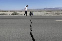 Ron Mikulaco, right, and Brad Fernandez examine a crack caused by an earthquake on Highway 178 outside Ridgecrest, Calif., July 6, 2019.