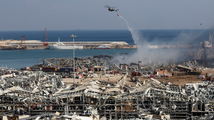 A Lebanese army helicopter throws water at the scene of an explosion that killed at least 100 and wounded thousands in Beirut, Aug. 5, 2020.