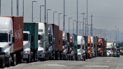 Trucks hauling shipping containers wait to unload at the Port of Oakland in Oakland, Calif., July 22, 2019.