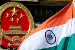 An Indian flag is flown next to the Chinese national emblem outside the Great Hall of the People, Beijing, Oct. 23, 2013.