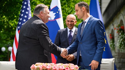 U.S. Secretary of State Mike Pompeo, left, and Slovenia's Foreign Minister Anze Logar shake hands as Slovenia's Prime Minister Janez Jansa stands at center, Bled, Slovenia, Aug. 13, 2020.