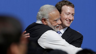 Facebook CEO Mark Zuckerberg hugs Indian Prime Minister Narendra Modi at Facebook, Menlo Park, Calif., Sept. 27, 2015.