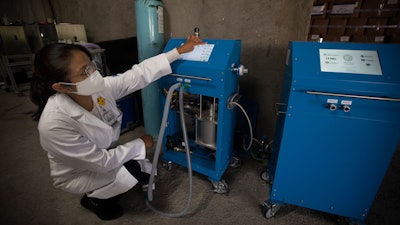Fanny Alvarado Chavez, head of the Biomedical Engineering department at the National Institute of Medical Science and Nutrition, with a VSZ-20-2 ventilator, Mexico City, Aug. 17, 2020.