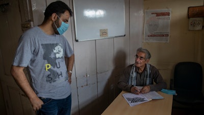 Parvez Imroz, right, a prominent Kashmiri human rights lawyer, talks to Khurram Parvez, an official of the Jammu-Kashmir Coalition of Civil Society, inside their office in Srinagar, Tuesday, Aug. 25, 2020.