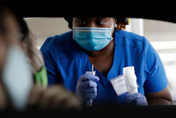 Healthcare worker Rahaana Smith instructs passengers at a drive-thru COVID-19 testing site at the Miami-Dade County Auditorium, Miami, July 24, 2020.