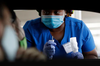 Healthcare worker Rahaana Smith instructs passengers at a drive-thru COVID-19 testing site at the Miami-Dade County Auditorium, Miami, July 24, 2020.