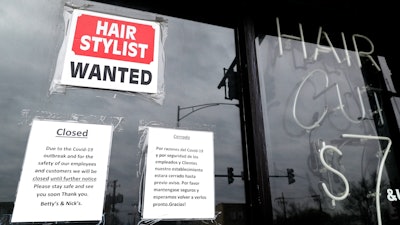 A barber shop shows closed and hiring signs in Chicago, April 30, 2020.