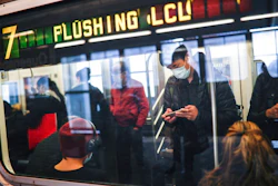 In this April 7, 2020, file photo, some people wear masks while using the New York City subway system during the coronavirus pandemic in New York. New York's mass transit agency wants Apple to come up with a better way for iPhone users to unlock their phones without taking off their masks, as it seeks to guard against the spread of COVID-19 in buses and subways.