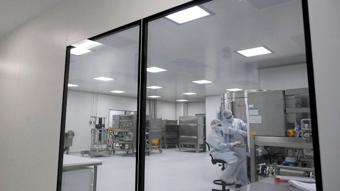 Laboratory technicians work at the mAbxience biopharmaceutical company on an experimental coronavirus vaccine developed by Oxford University and AstraZeneca, Garin, Argentina, Aug. 14, 2020.