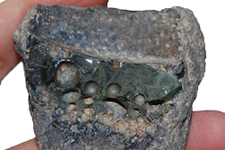 Crucible slag adhering to the interior of a crucible sherd.