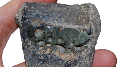 Crucible slag adhering to the interior of a crucible sherd.