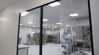 Laboratory technicians work at the mAbxience biopharmaceutical company on an experimental coronavirus vaccine developed by Oxford University and AstraZeneca, Garin, Argentina, Aug. 14, 2020.