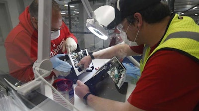 Ford Motor Co. employees work on a ventilator at the Rawsonville plant, Ypsilanti Township, Mich., May 13, 2020.