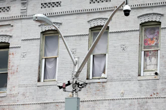 A surveillance camera, top right, and license plate scanners, center, at an intersection in West Baltimore, April 29, 2020.
