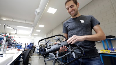 Adam Bry, founder and CEO of Skydio, holds the R1 flying camera drone while being interviewed in Redwood City, Calif., June 22, 2018.