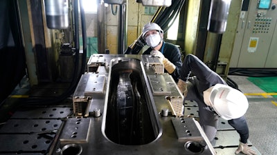 Nissan employees work on car parts made from carbon fiber reinforced plastics at the Nissan Technical Center in Atsugi, Japan, July 6, 2020.