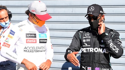 Mercedes driver Lewis Hamilton, right, talks with Mclaren driver Carlos Sainz at the Monza racetrack in Monza, Italy, Sept. 5, 2020.