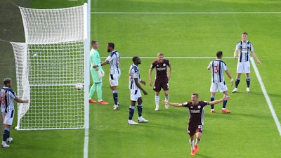 Leicester City's Timothy Castagne, bottom, celebrates after scoring against West Bromwich Albion at the Hawthorns, West Bromwich, England, Sept.13, 2020.