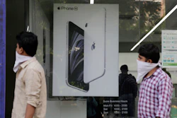 People walk past an image of an iPhone at an Apple store in Ahmedabad, India, Aug. 1, 2020.
