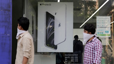 People walk past an image of an iPhone at an Apple store in Ahmedabad, India, Aug. 1, 2020.