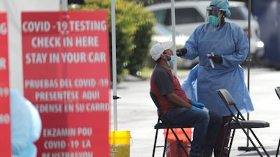 A health care worker administers a COVID-19 test at the Martin Luther King, Jr. Clinica Campesina Health Center in Homestead, Fla., July 6, 2020.