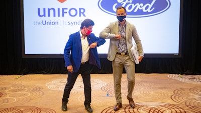 Unifor President Jerry Dias, left, elbow-bumps Ryan Kantautas, vice president of human resources at Ford Canada, at the start of formal contract talks with the Detroit Three automakers, Toronto, Aug. 12, 2020.
