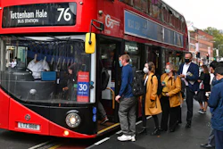 People board a bus outside Waterloo station in London.
