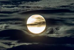 In this Sept. 2, 2020 file photo, the full moon shines surrounded by clouds in the outskirts of Frankfurt, Germany.