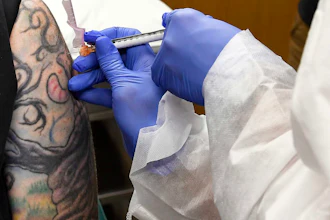 Melissa Harting, of Harpersville, N.Y., receives an injection as a study of a possible COVID-19 vaccine developed by the National Institutes of Health and Moderna Inc., Binghamton, N.Y., July 27, 2020.